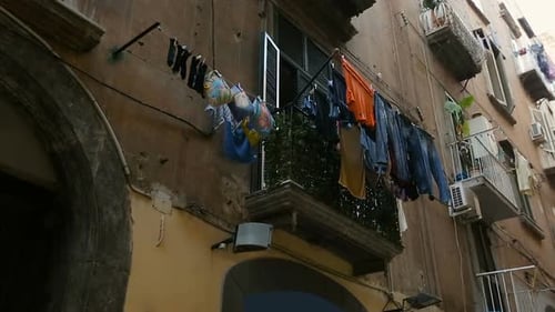 Dilapidated Residential Complex with Piles of Washed Laundry Drying on Balconies