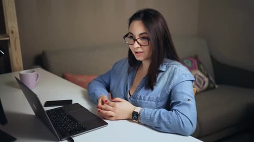 Woman Talking on a Video Call at Desk