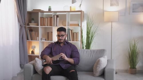 Man Working on Laptop in Bright Living Room