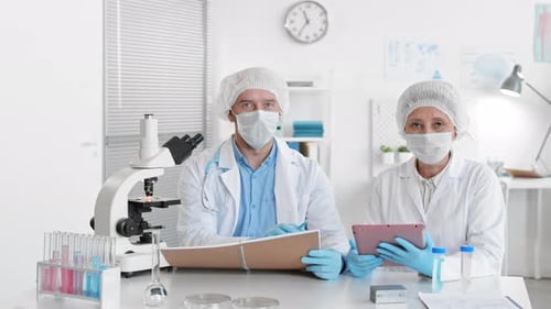 Scientists Working with Microscope and Tablet in Lab