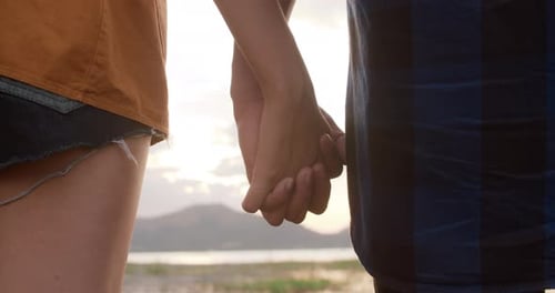 Young asia campers couple stand holding hands at campsite near beach.