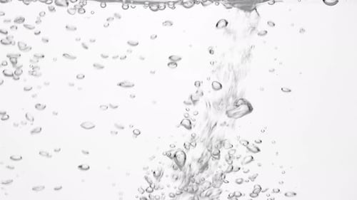 Trinkwasser in Glas über Weiß gießen