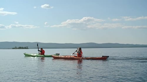 Kayakers Paddling Across Lake on a Sunny Day
