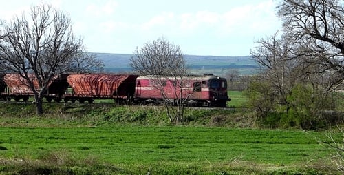 Freight Train Moving Through a Green Rural Landscape