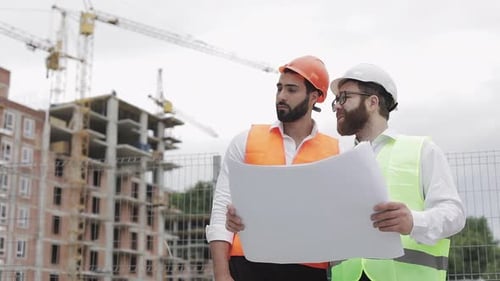 Male Construction Engineer Discussion with Architect at Construction Site or Building Site of