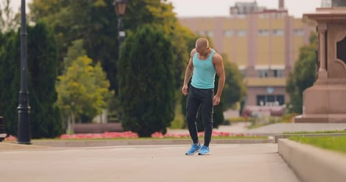 Athletic Man Stretching Leg in City Park