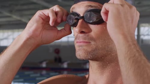 Swimmer putting his pool goggles