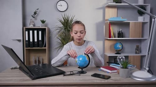 Girl Examining Globe With a Magnifying Glass