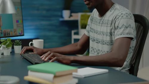 Graphic Designer Wearing Headphones and Retouching Pictures