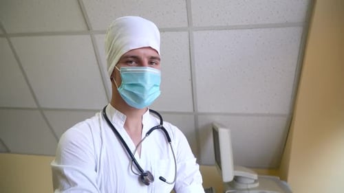 Doctor with Stethoscope in Protective Mask Looking at the Camera. Hospital with Ultrasound Devices