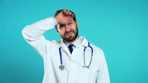 Concerned Doctor Wipes Brow on Isolated Background