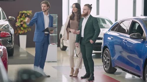Wide Shot Portrait of Confident Young Rich Couple Choosing New Automobile in Car Dealership