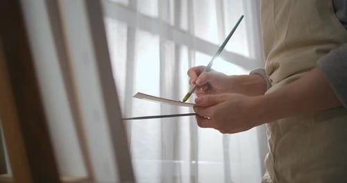 Professionelle Künstlerin Frau arbeitet im Studio Malerei Bild auf Leinwand Mischen von Farben auf Palette