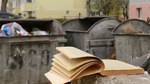 Libro amarillento arrojado al basurero