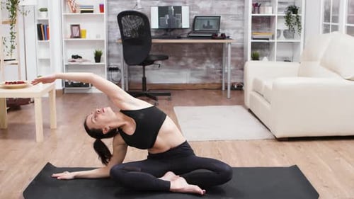 Woman Practices Yoga at Home on Yoga Mat