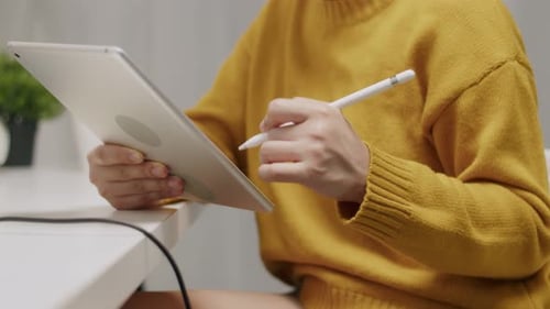 Woman Using Tablet with Stylus at Desk
