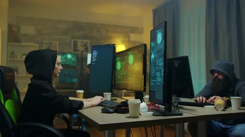 Young Team Hacking at Computers at Night