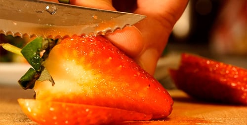 Strawberry Slicing with Knife on Cutting Board