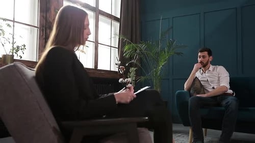 Woman Counseling a Man in Comfortable Office Setting