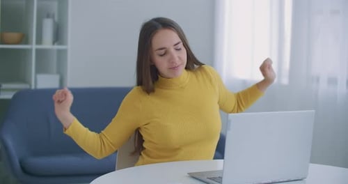 A Woman Sitting in the Office Warms Her Back. Posture and Back Problems While Working