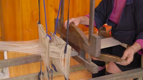 A Local Woman From Black Hmong Ctribe Weaves Black Fabric on Traditional Wooden Weaving Machine in a