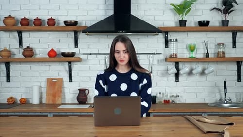Young Woman Working on Laptop in Kitchen