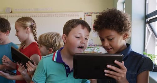 Gruppe von Kindern, die in der Klasse ein digitales Tablet nutzen