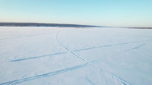 Footprints In The Snow Of A Frozen River