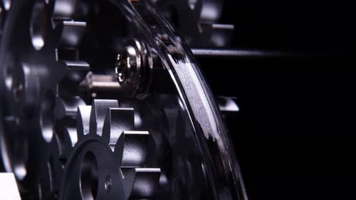 Close Up of Rotating Metal Gears on Black