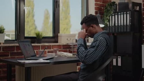 Frustrated Young Adult Working at Computer in Office