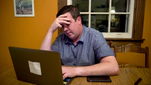 Man Working on Laptop at Home at Night