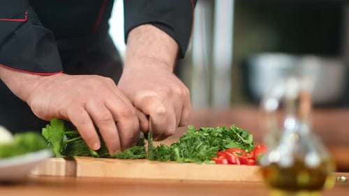 Chef Chopping Herbs on Cutting Board for Recipe