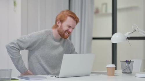 Man Experiencing Back Pain While Working on Laptop