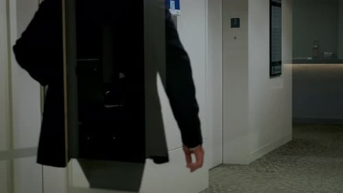 El hombre presiona el botón del elevador para subir