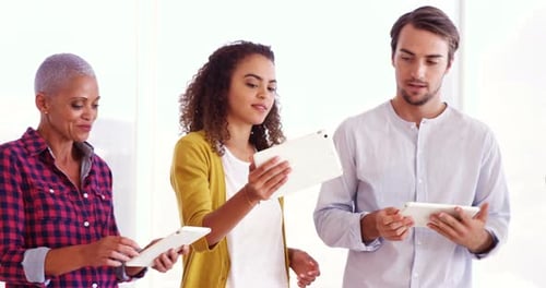 Smiling executives using digital tablet