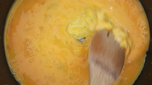 Cooking Eggs with Wooden Spoon Overhead Shot