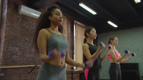 Women Working Out with Dumbbells at the Gym