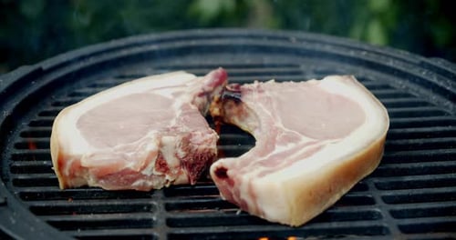 Pork Chops Cooking on a Black Grill