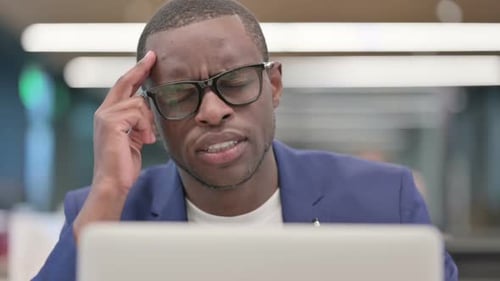 Tired Man Working at Laptop in Office