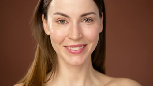 Woman smiling, touching face