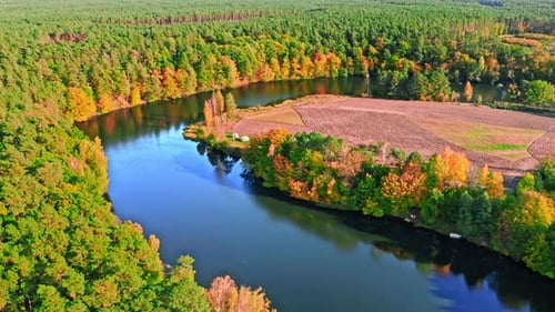 Blue river and colorful forest in autumn, aerial view