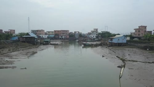 Aerial shot of a polluted river near the village in Asia