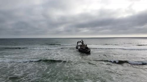 Gran barco hundido cerca de la costa, Skeleton Coast en Namibia, día nublado
