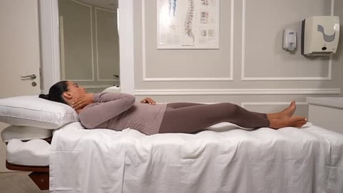 Woman Lying on Medical Table in Examination Room