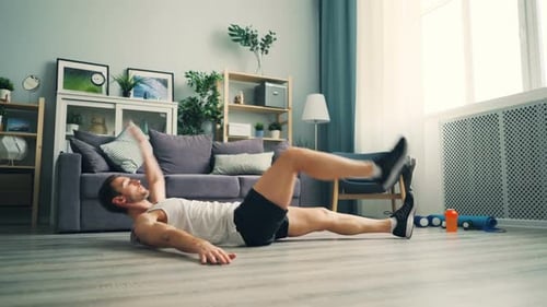 Man Doing Bicycle Crunches in Living Room