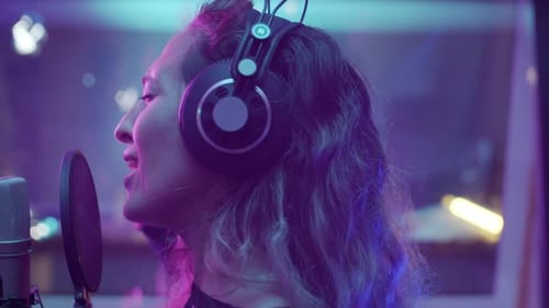 Female Singer Recording Song in Studio