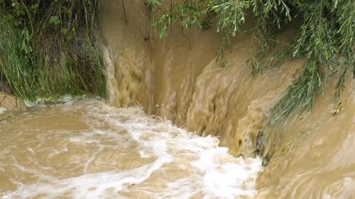 Schmutziger Fluss mit schlammigem Wasser in Überschwemmungszeit bei starken Regenfällen im Frühjahr.