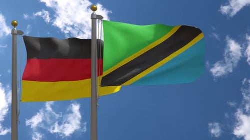 Waving Flags of Germany and Tanzania on Sunny Day