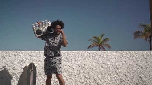 Man Dancing with Boombox in Tropical Setting