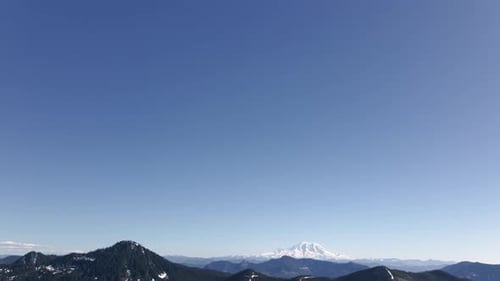 Snow Capped Mountain Peaks Against Crisp Blue Sky